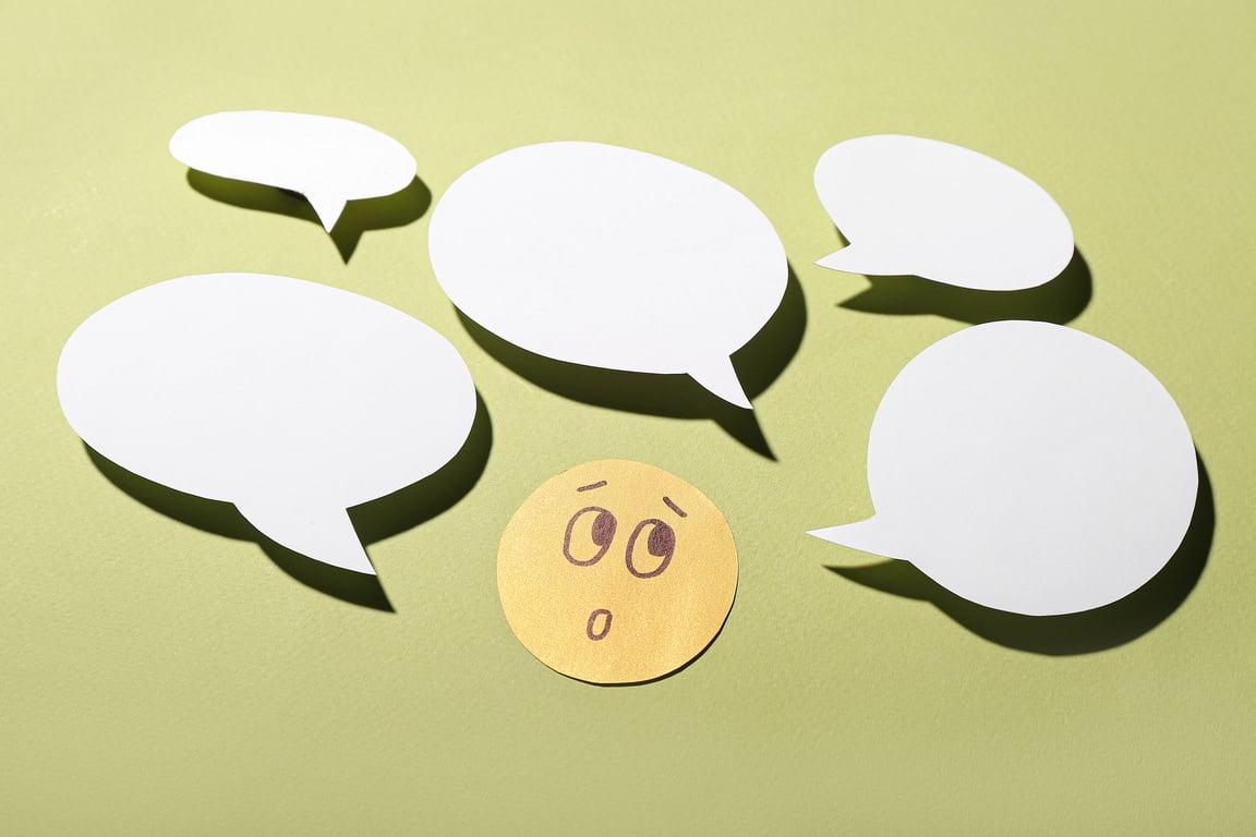 Paper Face with Speech Bubbles on Green Background. Dialogue Concept